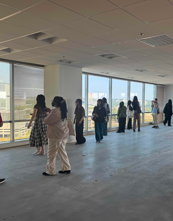 Group walking through a glass-walled room overlooking the skyline